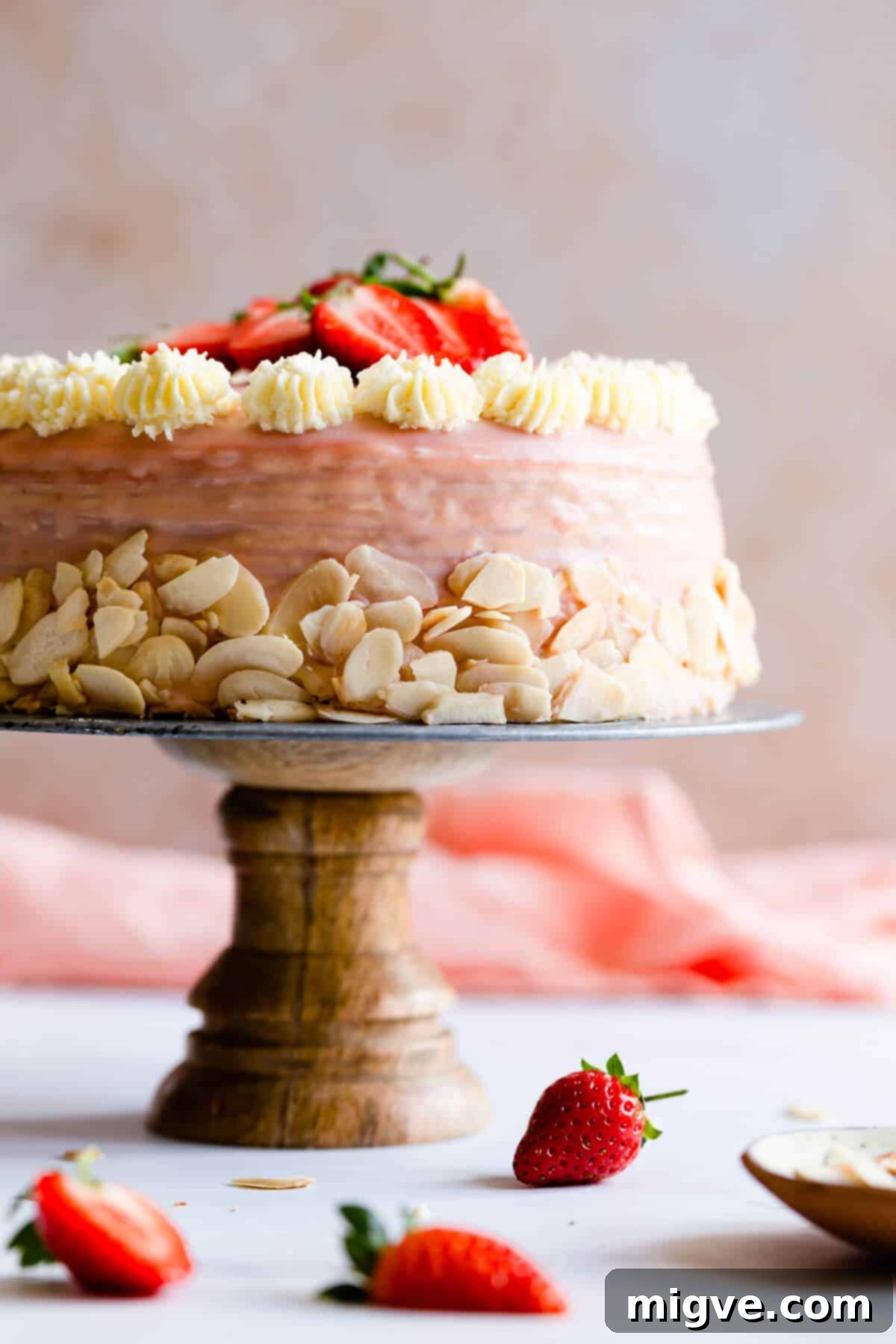 straight ahead close up of strawberry crepe cake on a cake stand