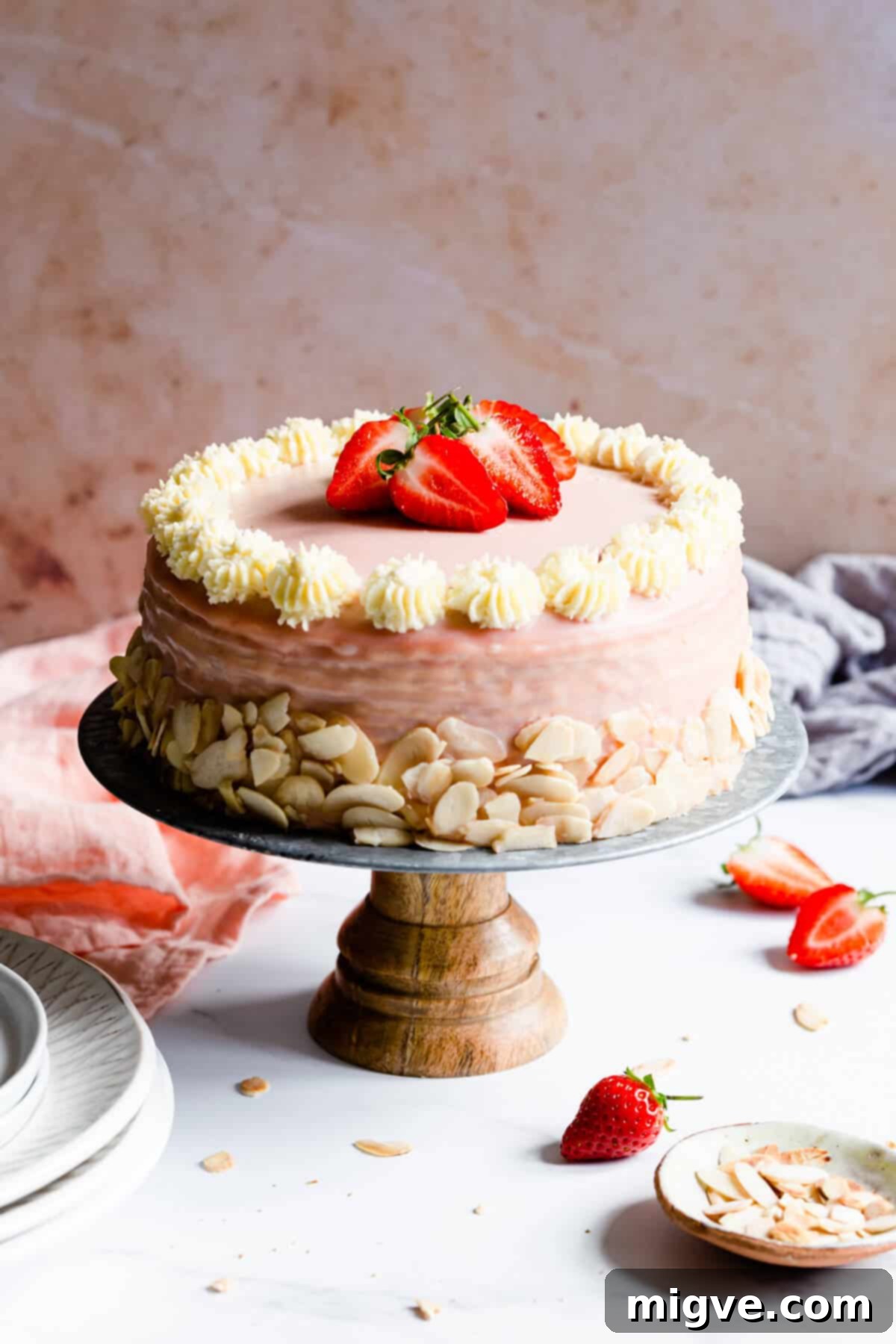 side close up of a strawberry crepe cake topped with fresh strawberries