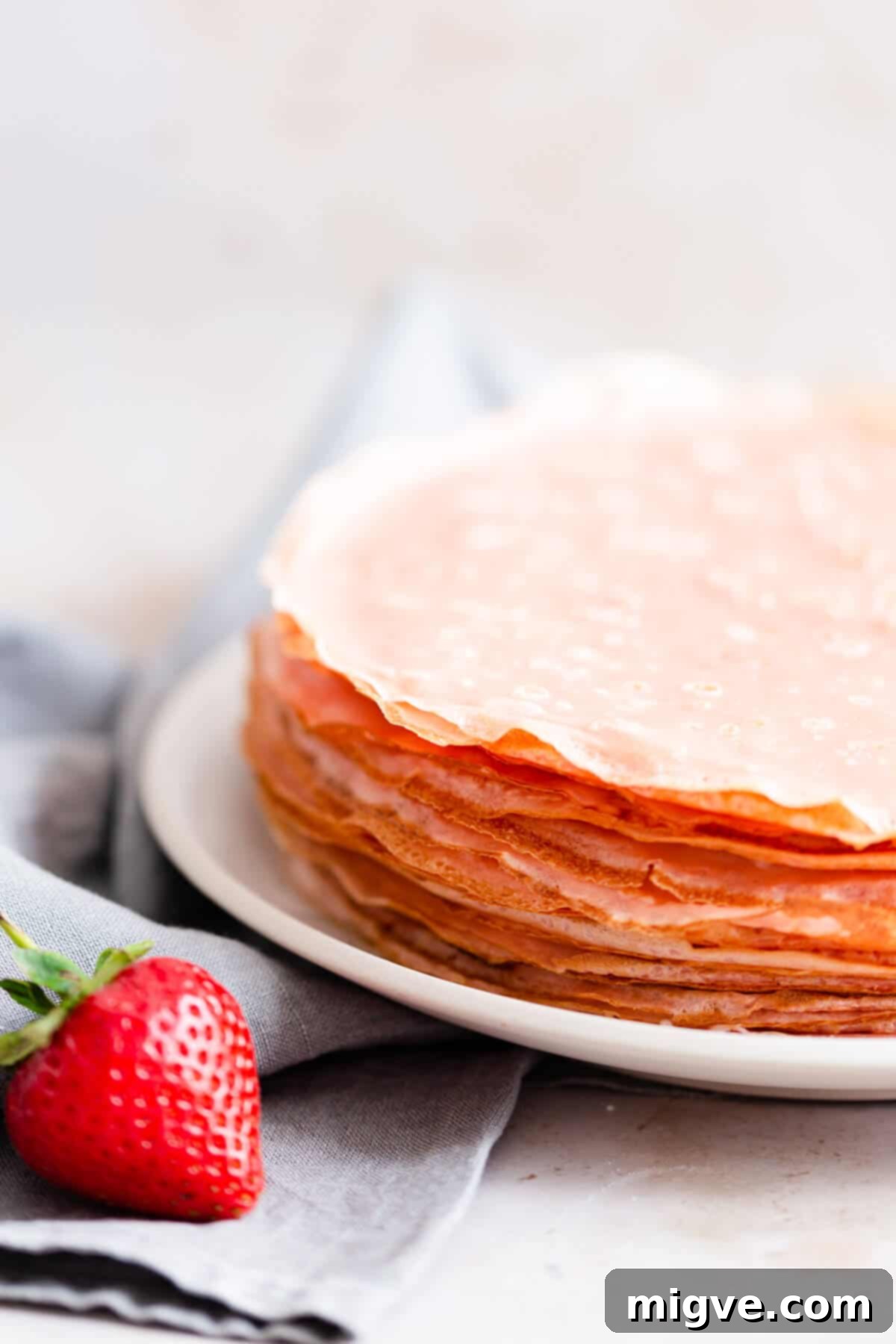 side close up of pink crepes on a plate