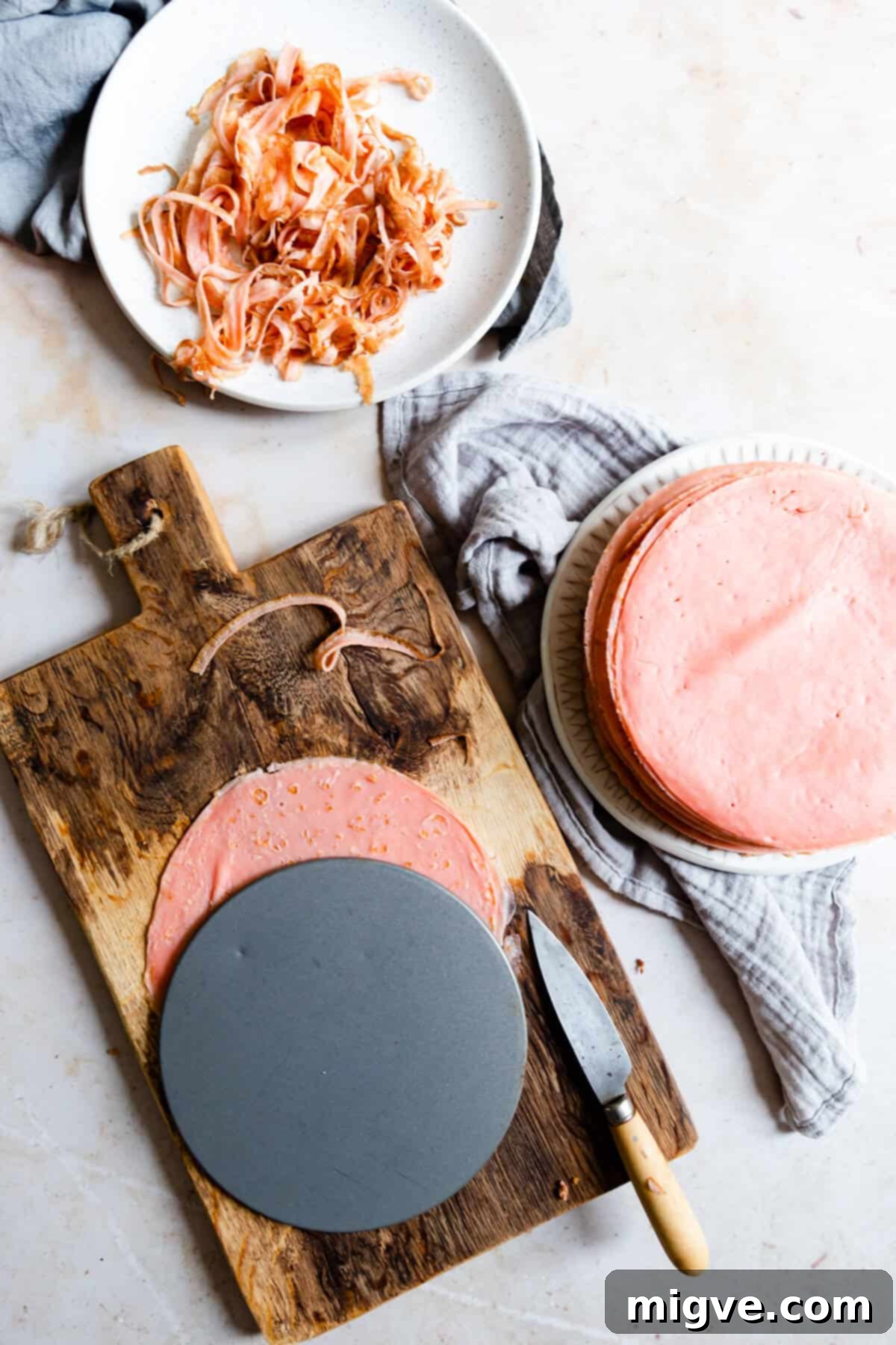 top view of crepes being trimmed on a chopping board