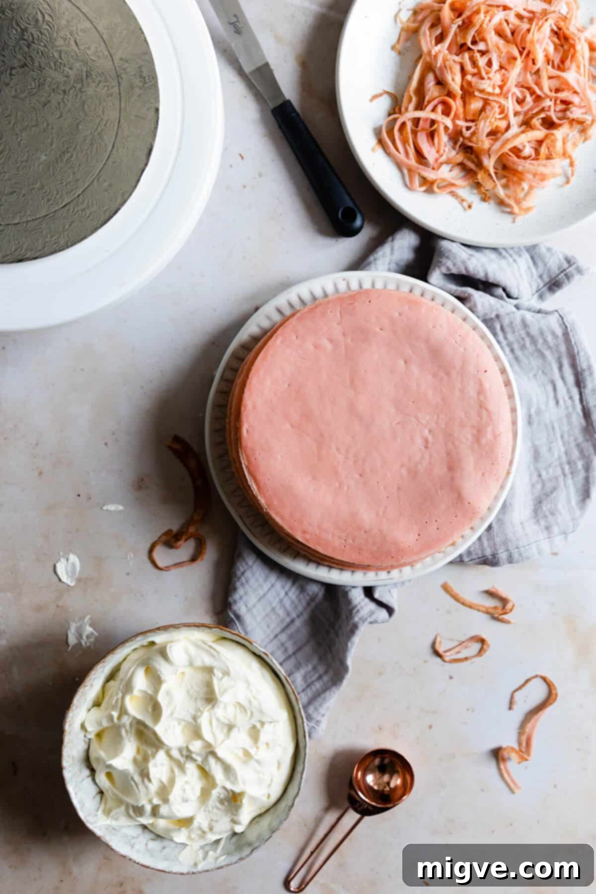overhead process shot of pink crepes and a bowl of whipped cream