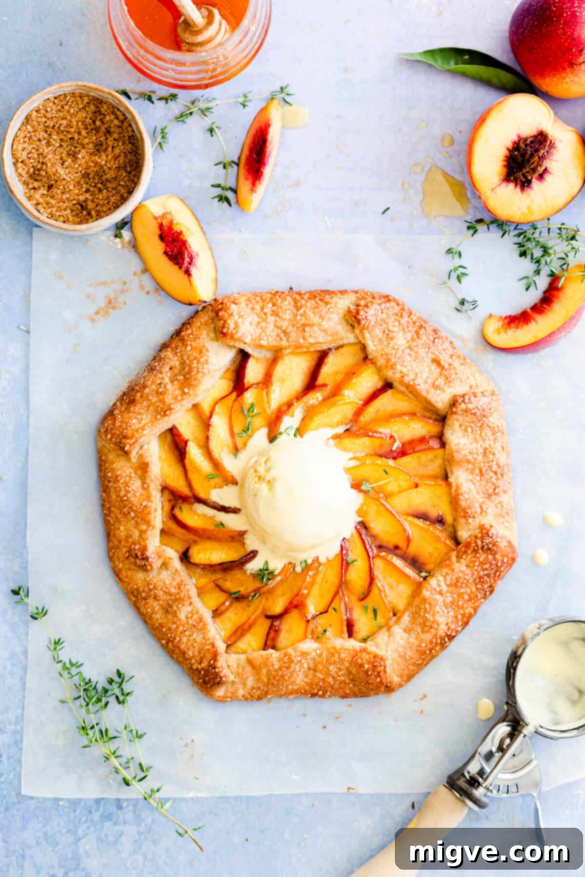 overhead shot of peach galette with a scoop of ice cream on top, ready to be served as a summer dessert