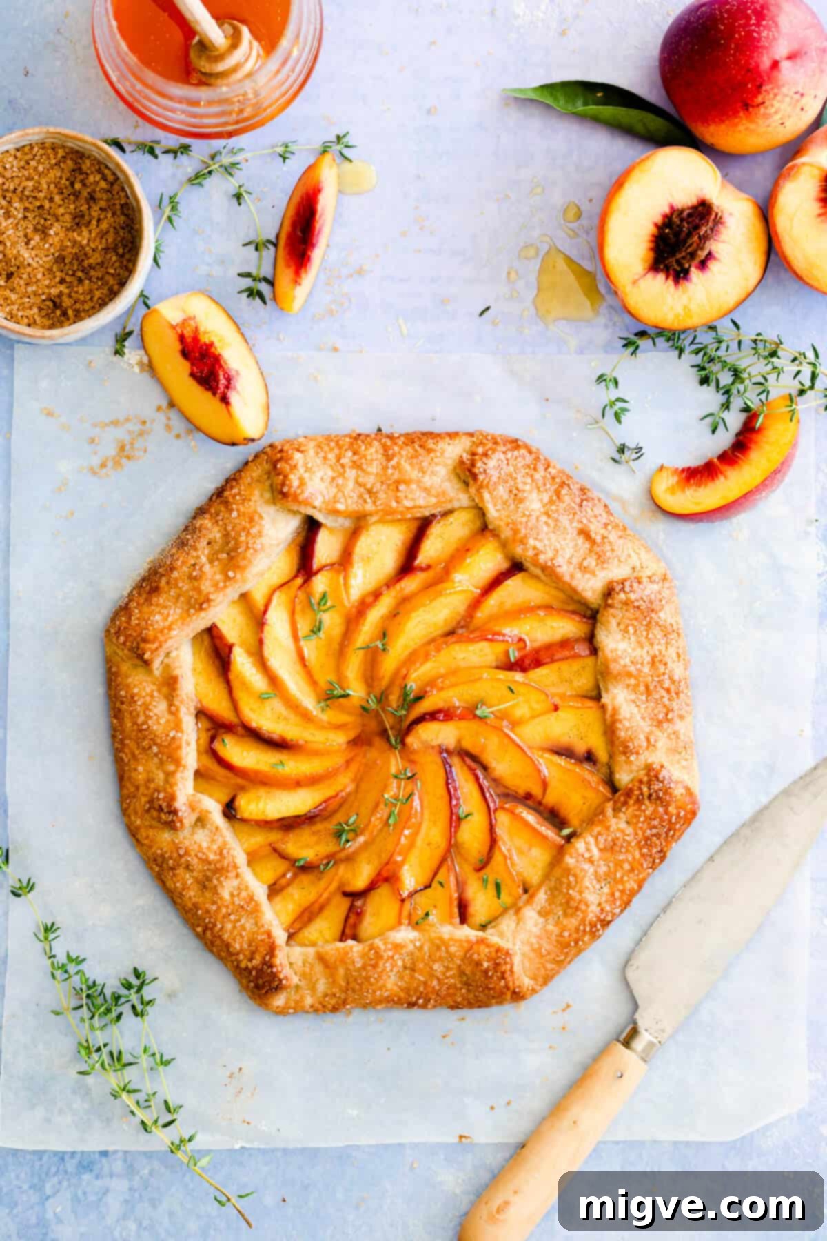 overhead shot of a golden brown sugar peach galette with fresh thyme sprigs on top