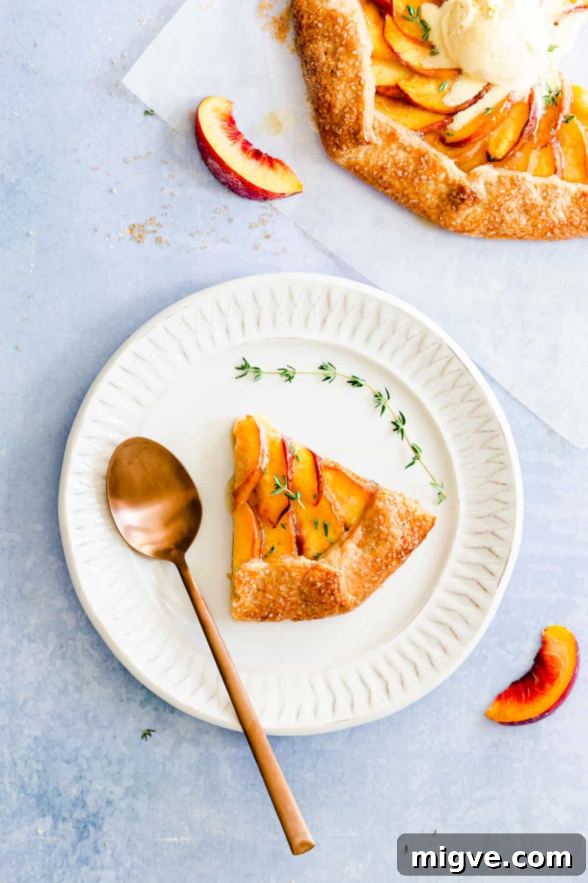 top view of a generous slice of peach galette on a pristine white plate