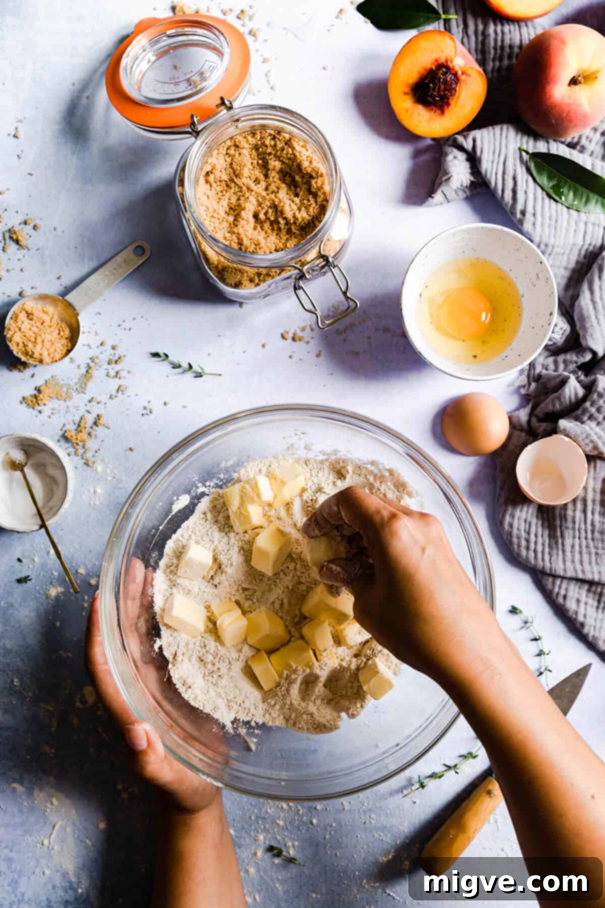 overhead shot of person gently rubbing cold butter cubes into flour mixture for galette pastry