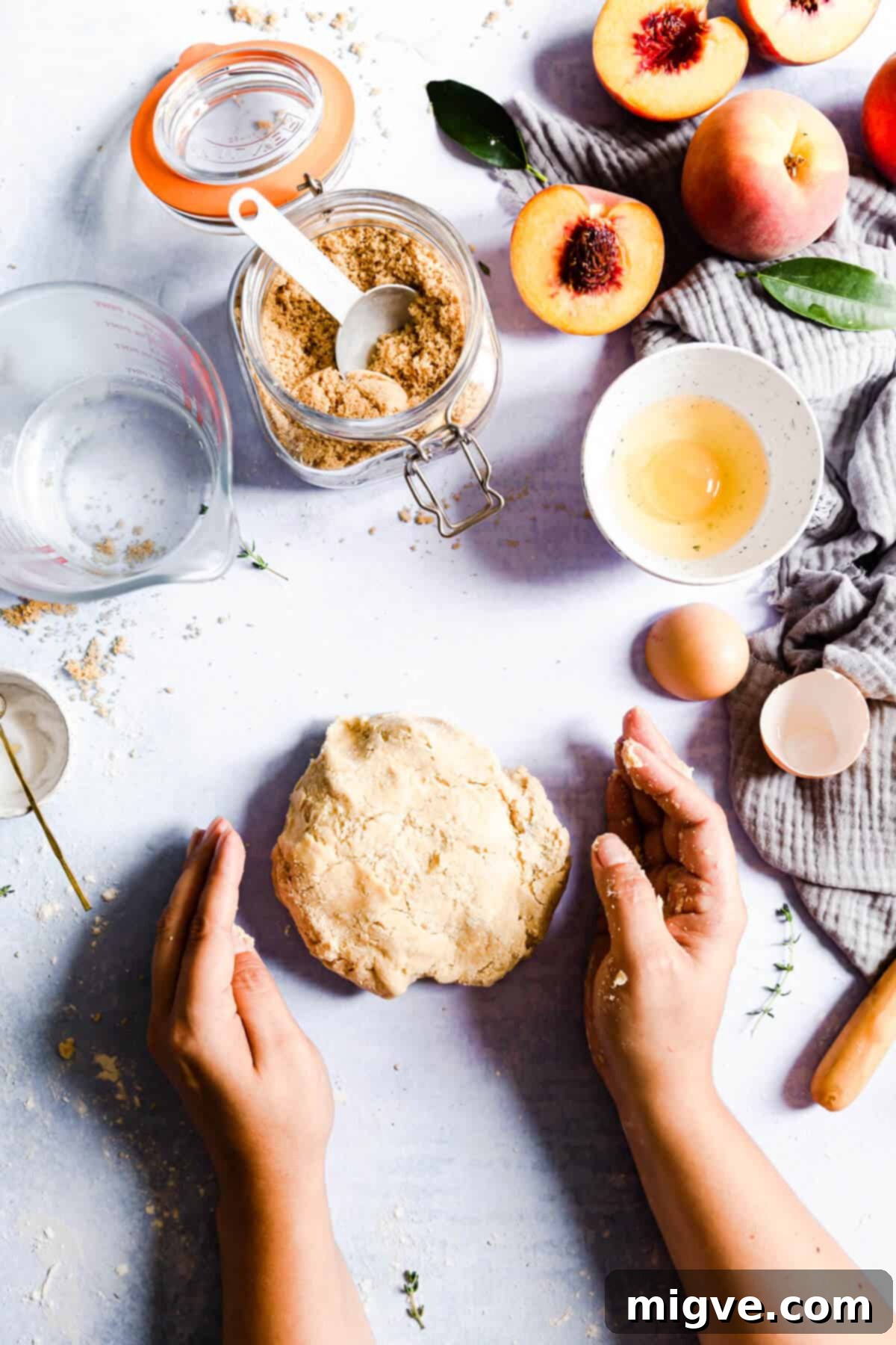 overhead shot of galette dough being gently kneaded into a smooth, cohesive ball