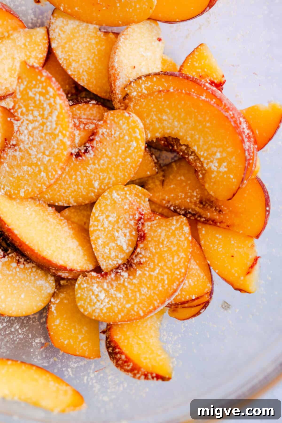 close up of perfectly sliced peaches, lightly dusted with cornflour for a peach galette