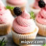 Super close-up of a cupcake topped with pink blackberry buttercream