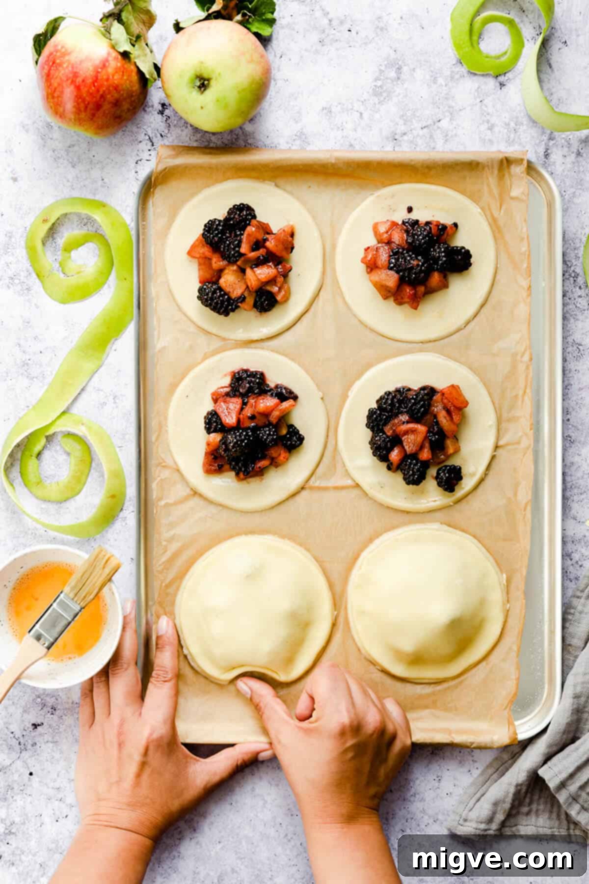 top view of a person shaping pastry circles into apples