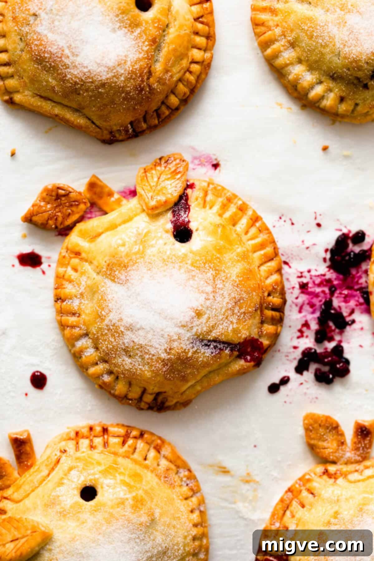 super close up of baked hand pie sprinkled with caster sugar with juices oozing out