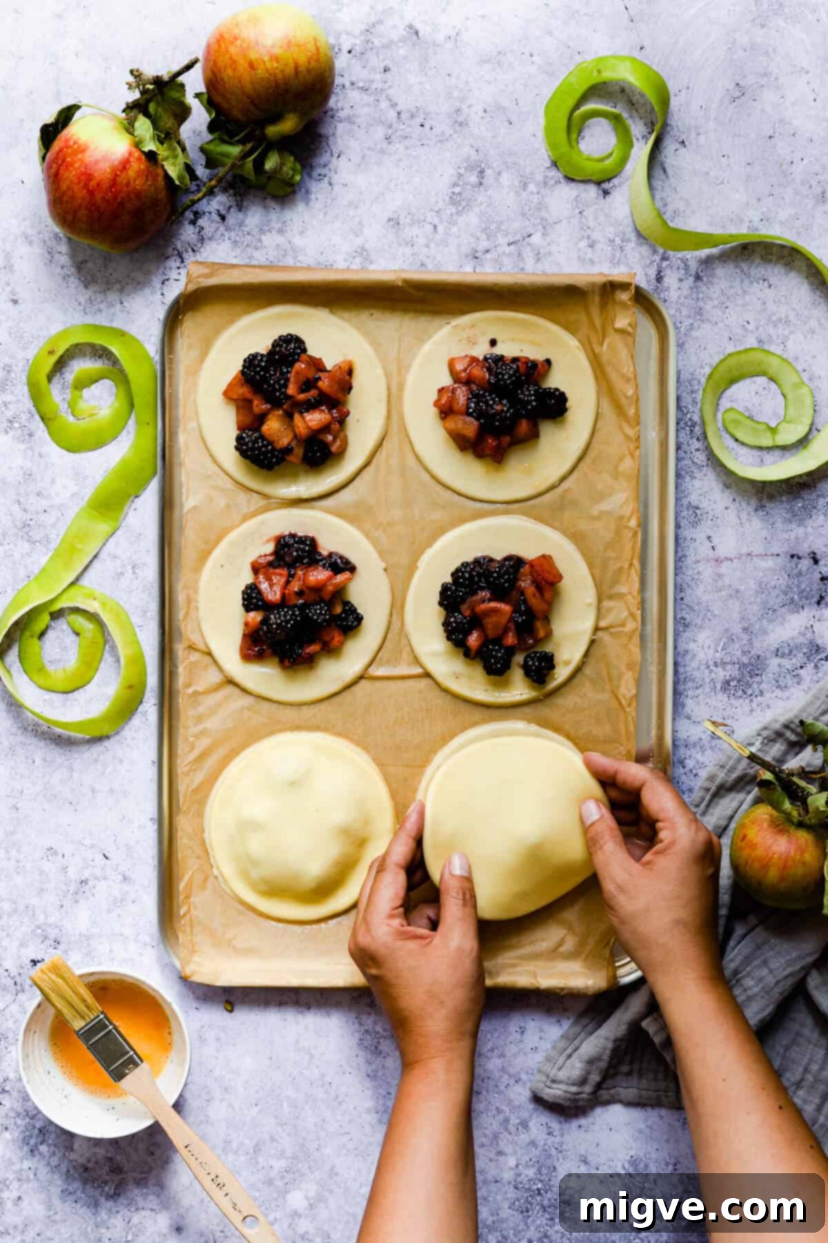 top view of a person pressing a pastry circle on top of another one
