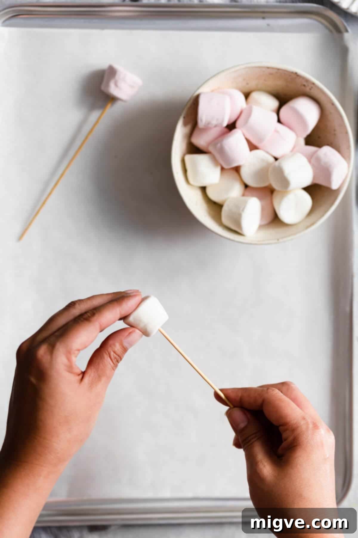 Midnight Marshmallow Bats 5 overhead shot of a person poking a bamboo skewer through a marshmallow