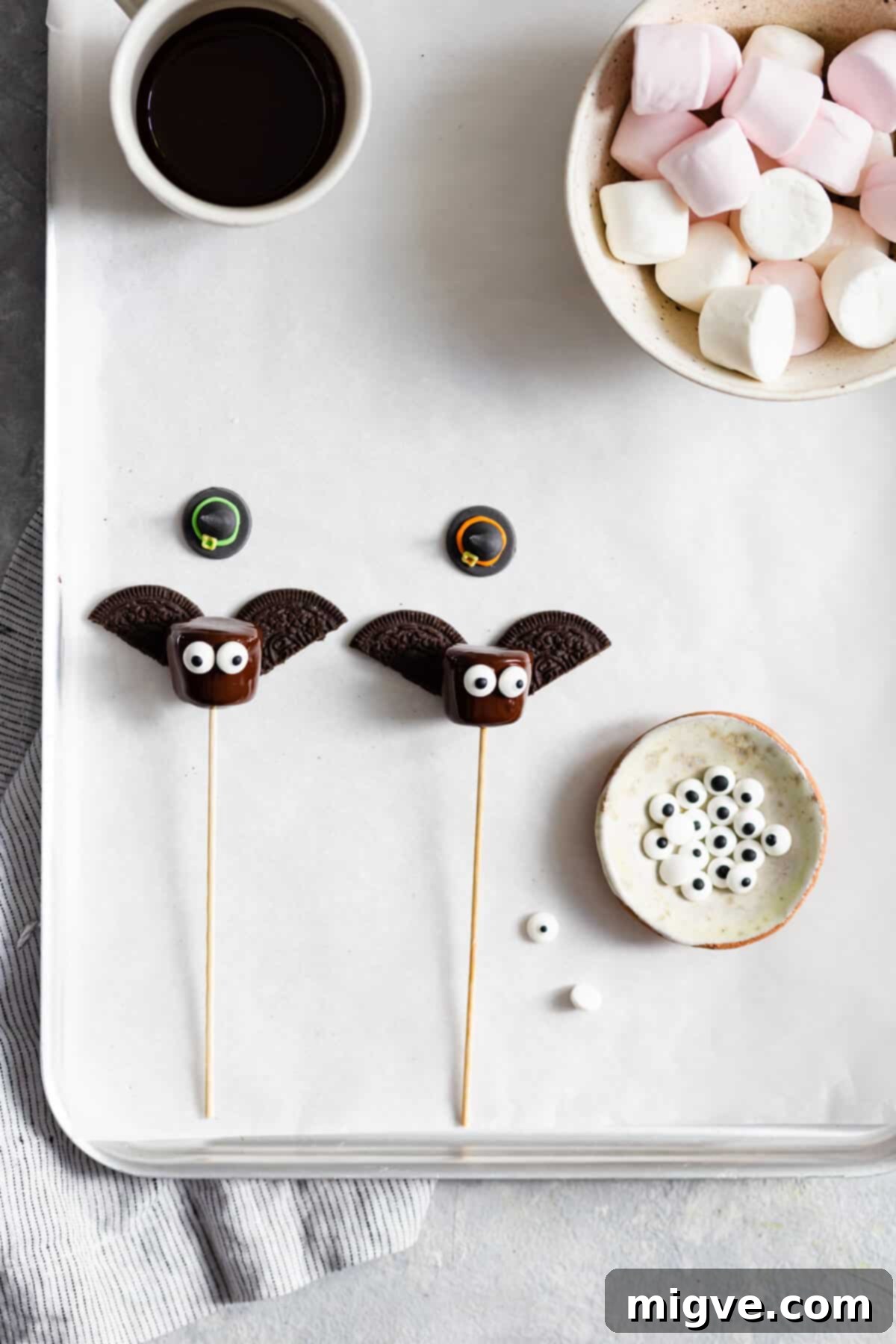 Midnight Marshmallow Bats 7 overhead shot of chocolate dipped marshmallows with cookie wings and sugar eyes attached to them