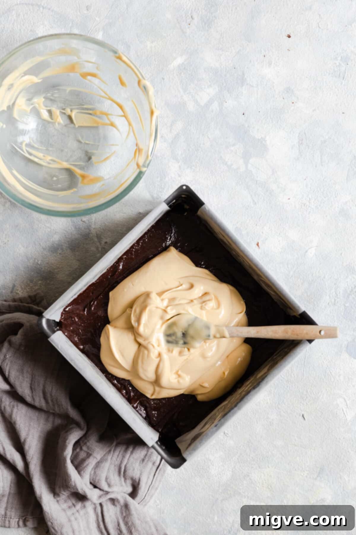 top view of baking tin with brownie and cheesecake batter