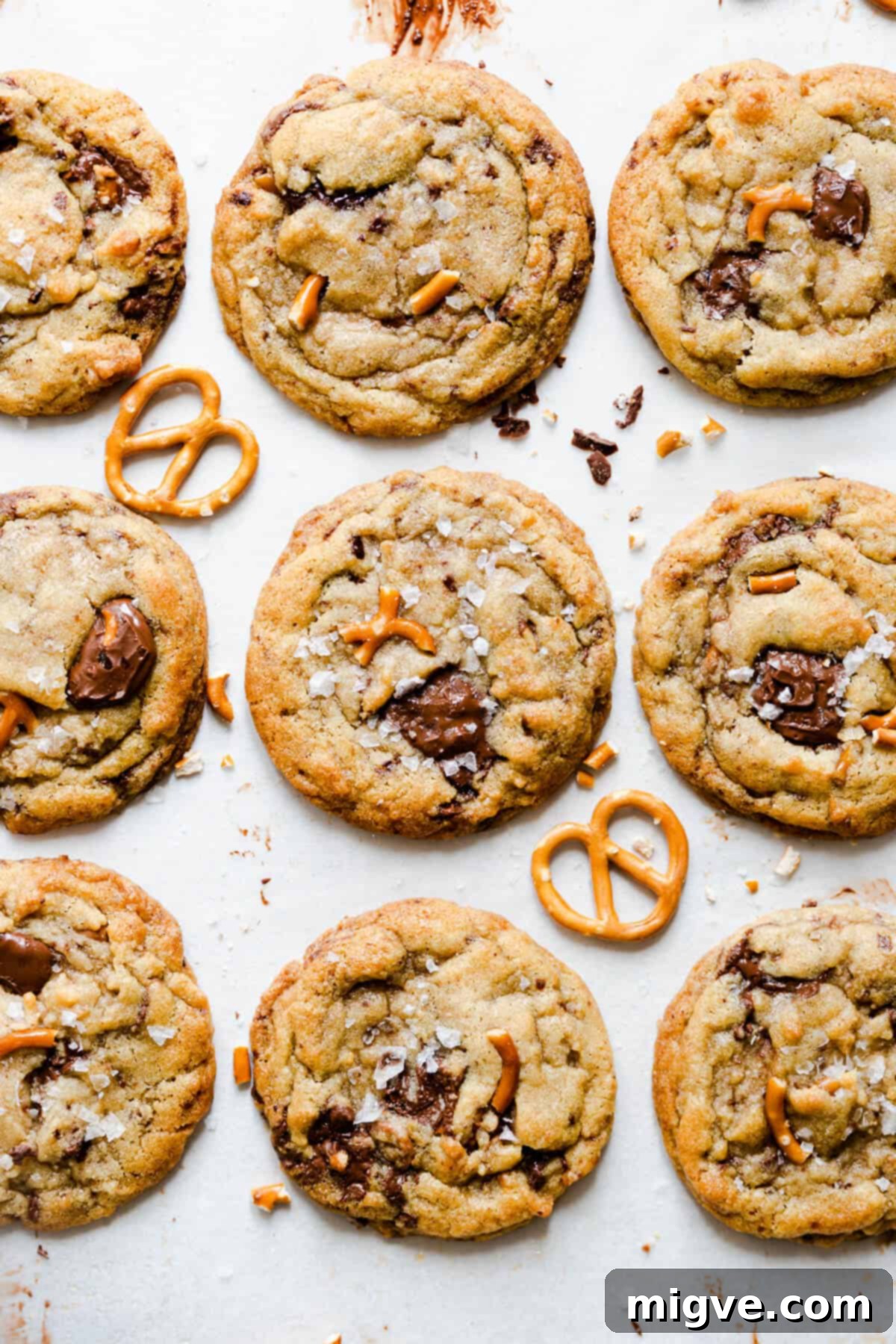 Close-up top view of freshly baked chocolate pretzel cookies on a cooling rack, showcasing the glistening melted chocolate chunks and visible pretzel pieces.