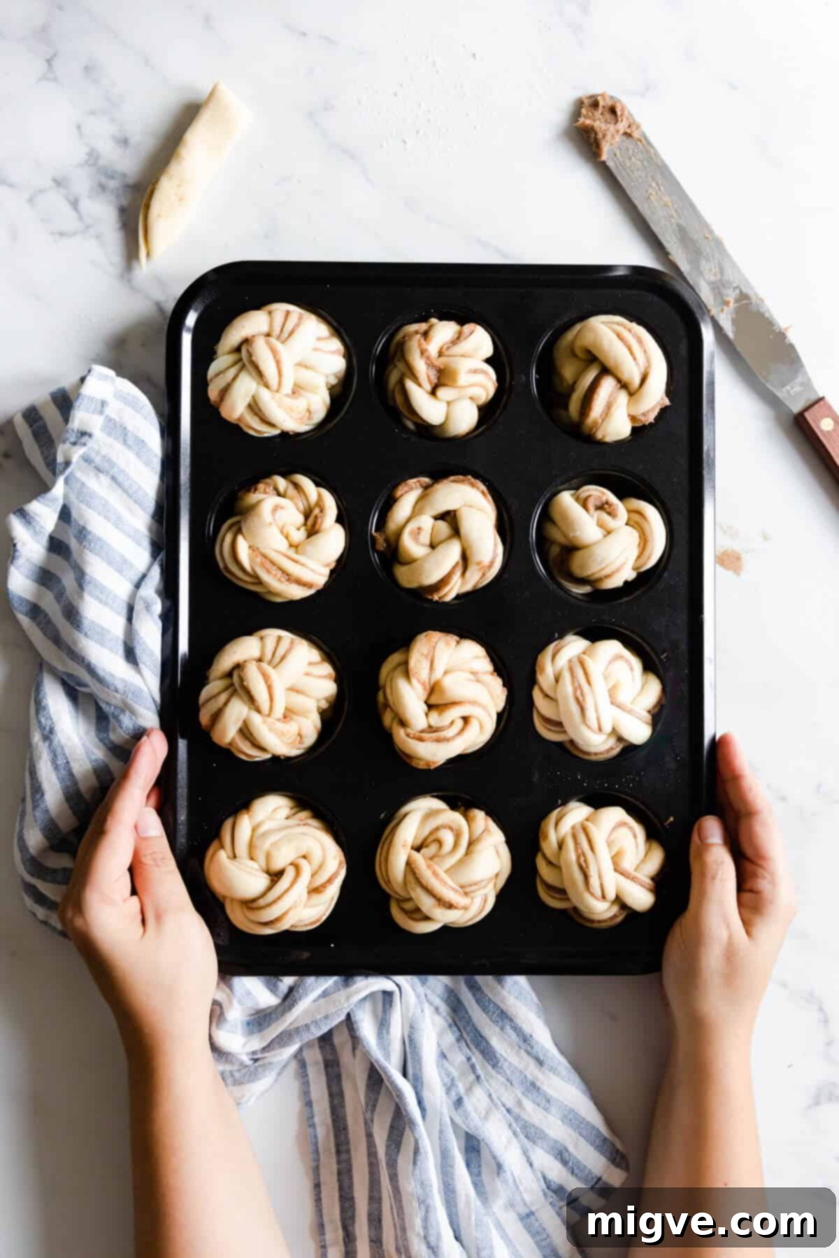 top view of a muffin tray filled with unbaked cinnamon buns