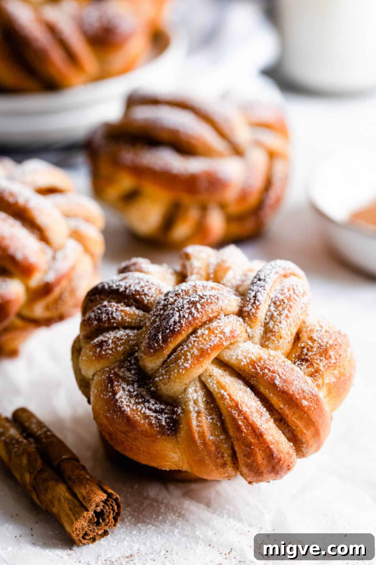 side close up at twisted cinnamon roll dusted with icing sugar