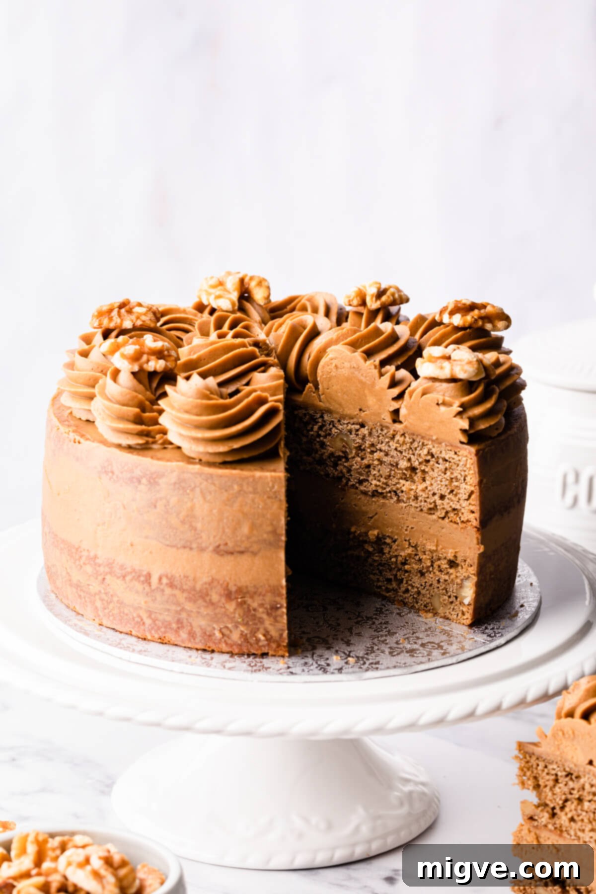 walnut and coffee cake with a slice cut out of it.
