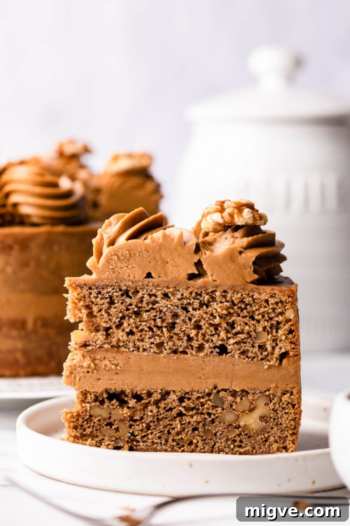 a single slice of walnut cake on a dessert plate.