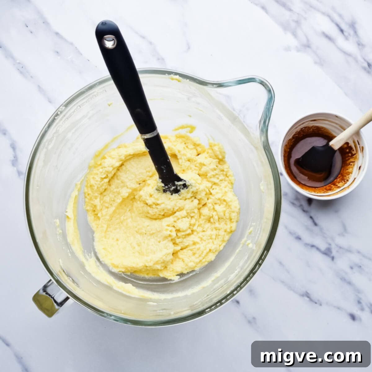 a glass bowl with creamed butter, sugar and eggs.