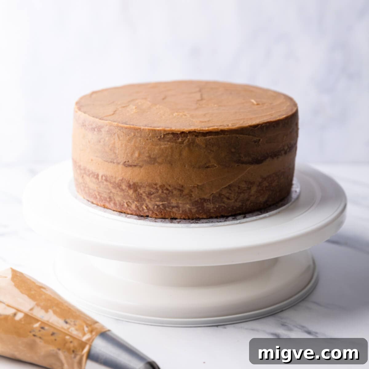 coffee cake with crumb coating on a cake turntable.