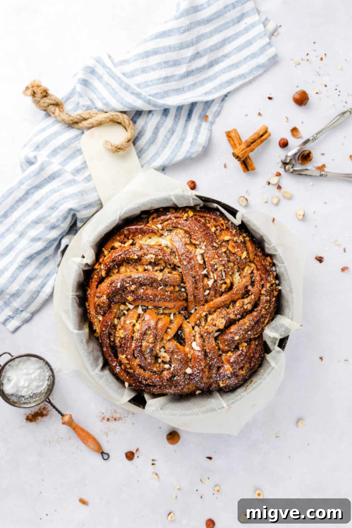top view of twisted cinnamon bread inside of the baking tin and dusted with icing sugar