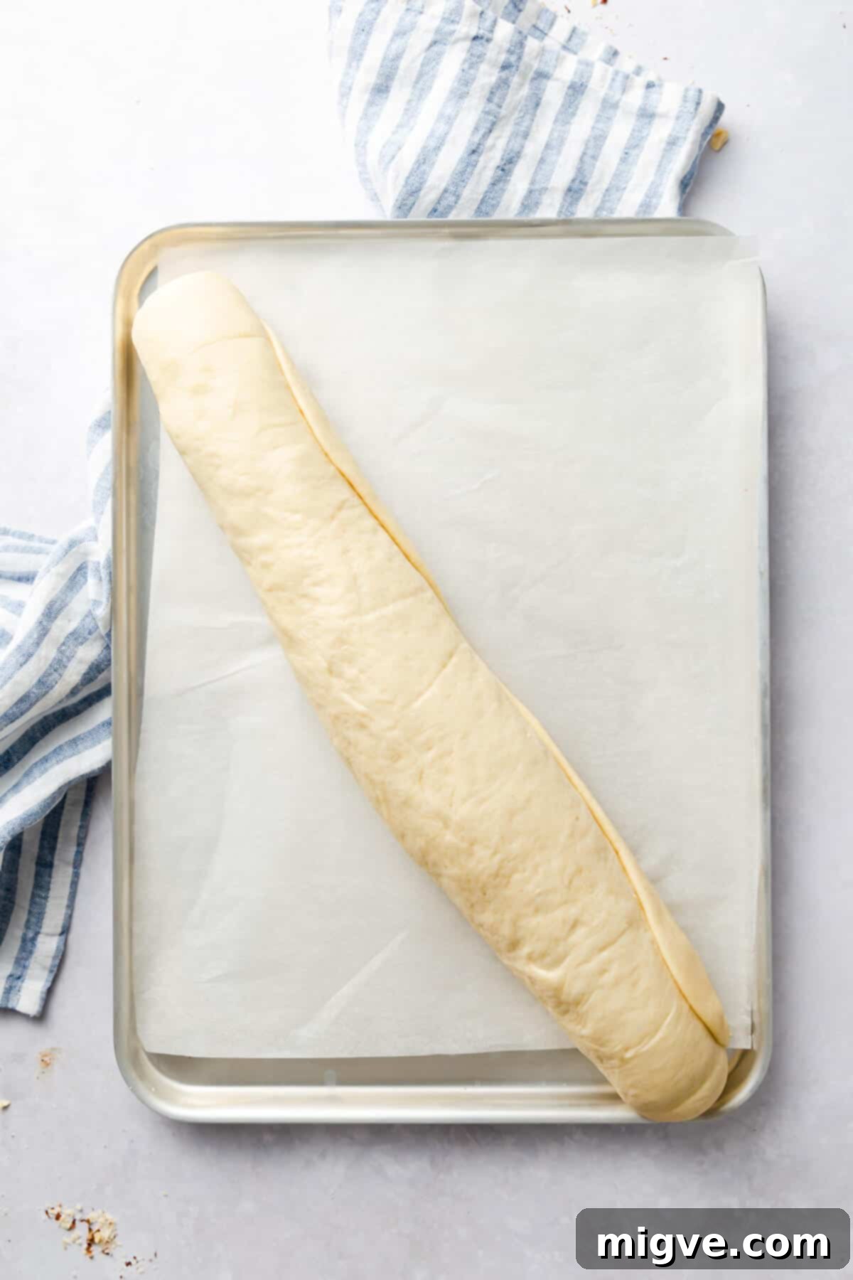overhead shot of a dough rolled into a log on a baking tray
