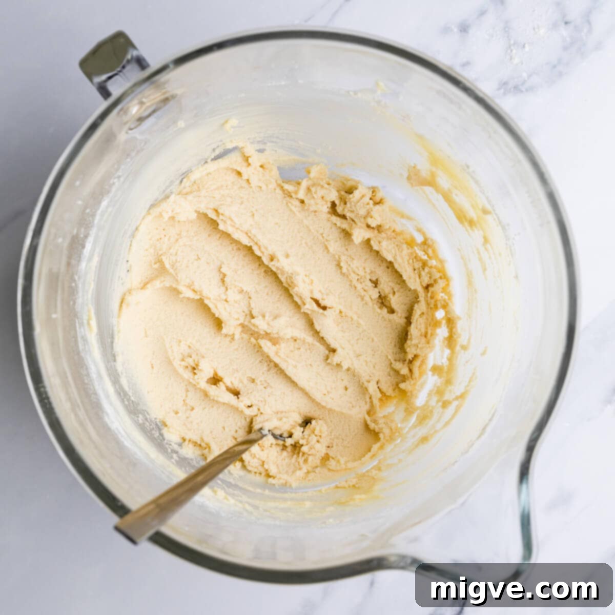Buttery Danish Cookie Perfection 5 A glass bowl containing smooth, thick cookie dough, ready for piping.