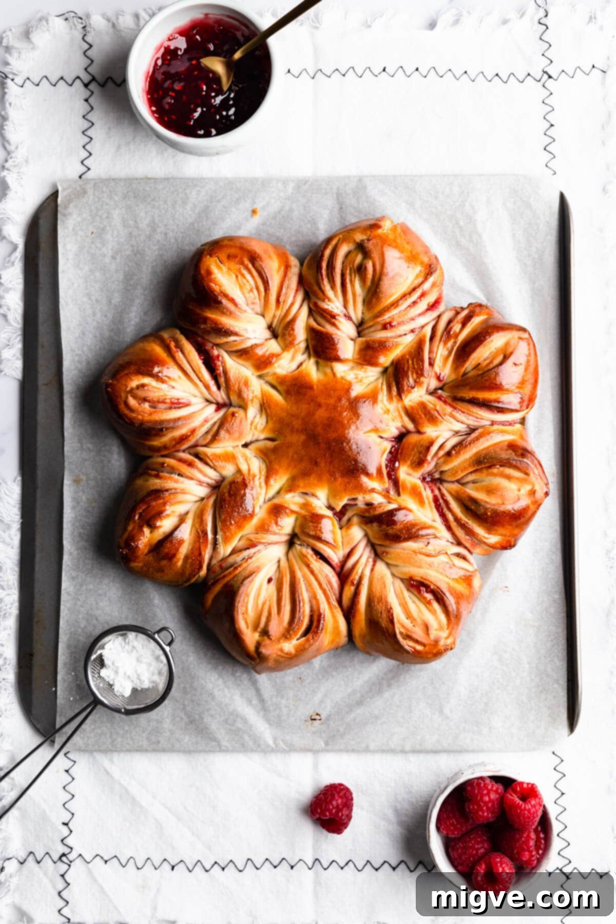 overhead view at festive bread shaped like a snowflake on a baking tray