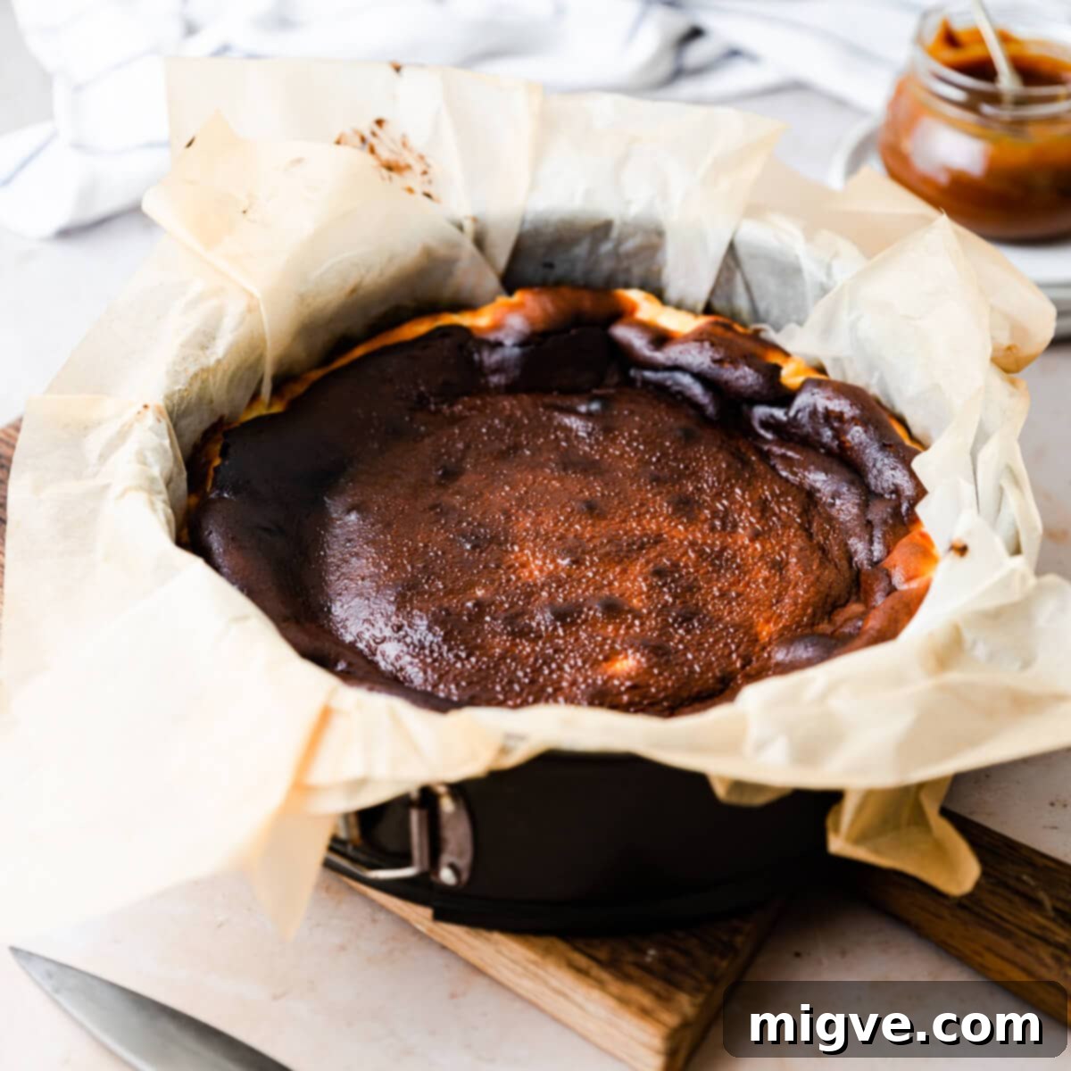 burnt cheesecake inside of the baking tin lined with plenty of baking paper, cooling down.