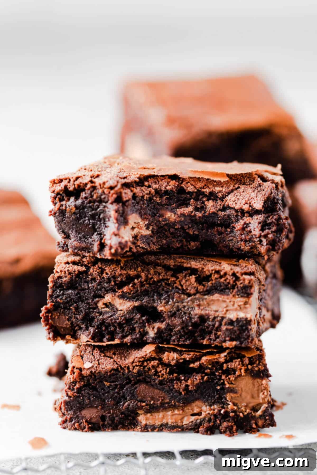 Foolproof Fudgy Brownies 2 side close up at a stack of three brownies with the top one missing a bite