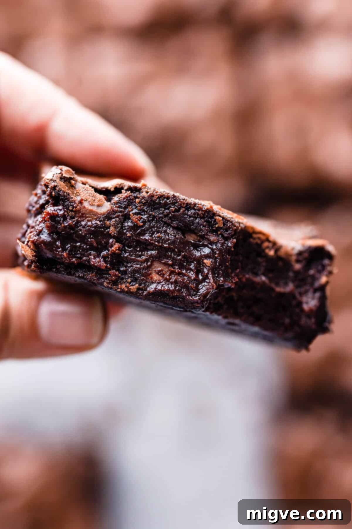 Foolproof Fudgy Brownies 4 super close up of a person holding a slice of brownie showing it's gooey texture