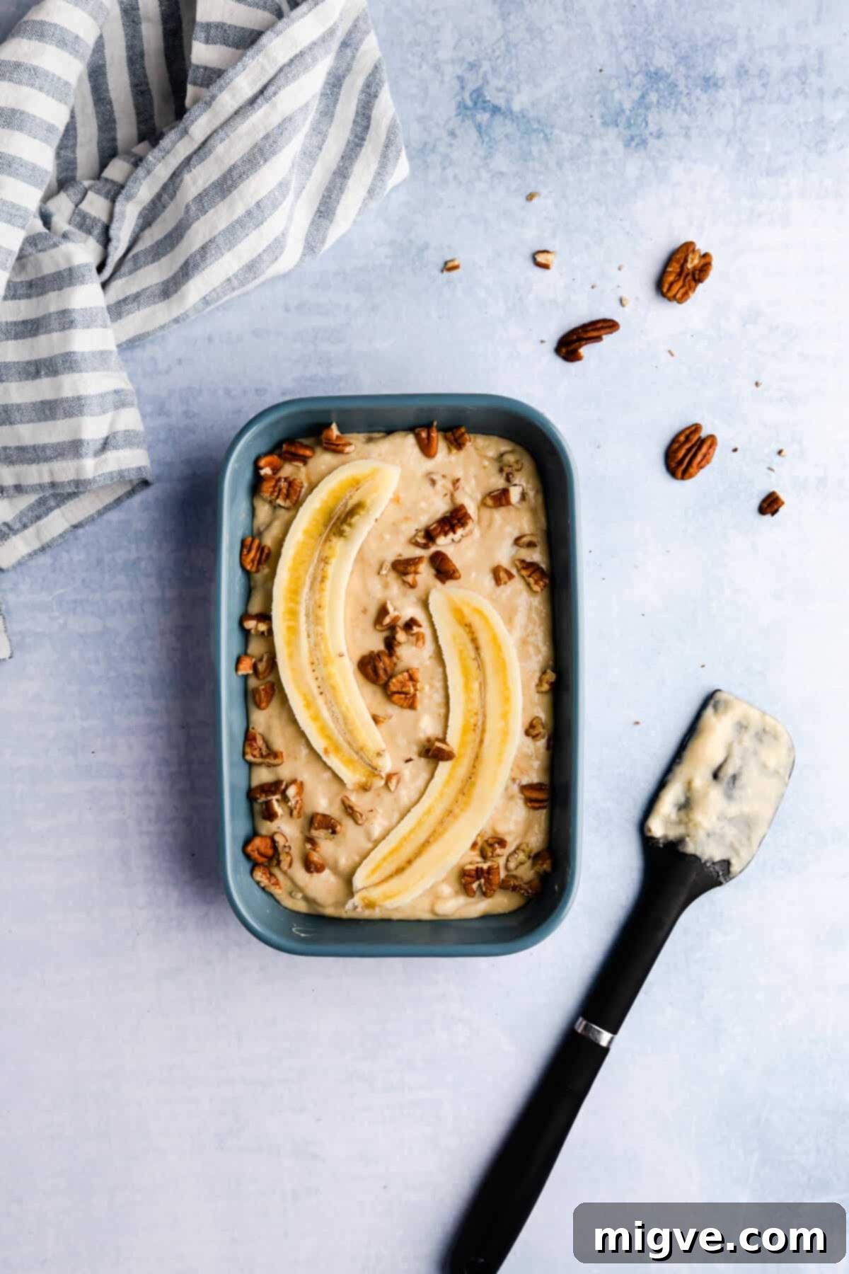 Top view of a small rectangular baking dish perfectly filled with smooth pudding batter, ready for its toppings