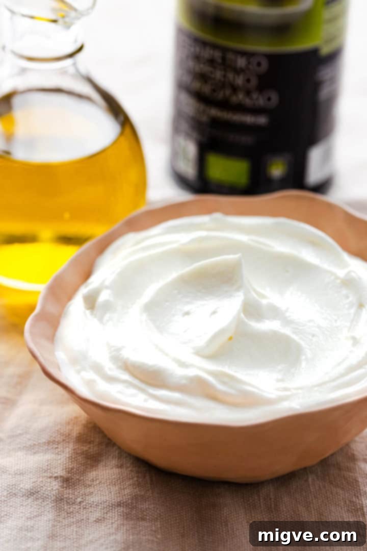 side close up of a bowl with Greek yogurt and some olive oil in the background