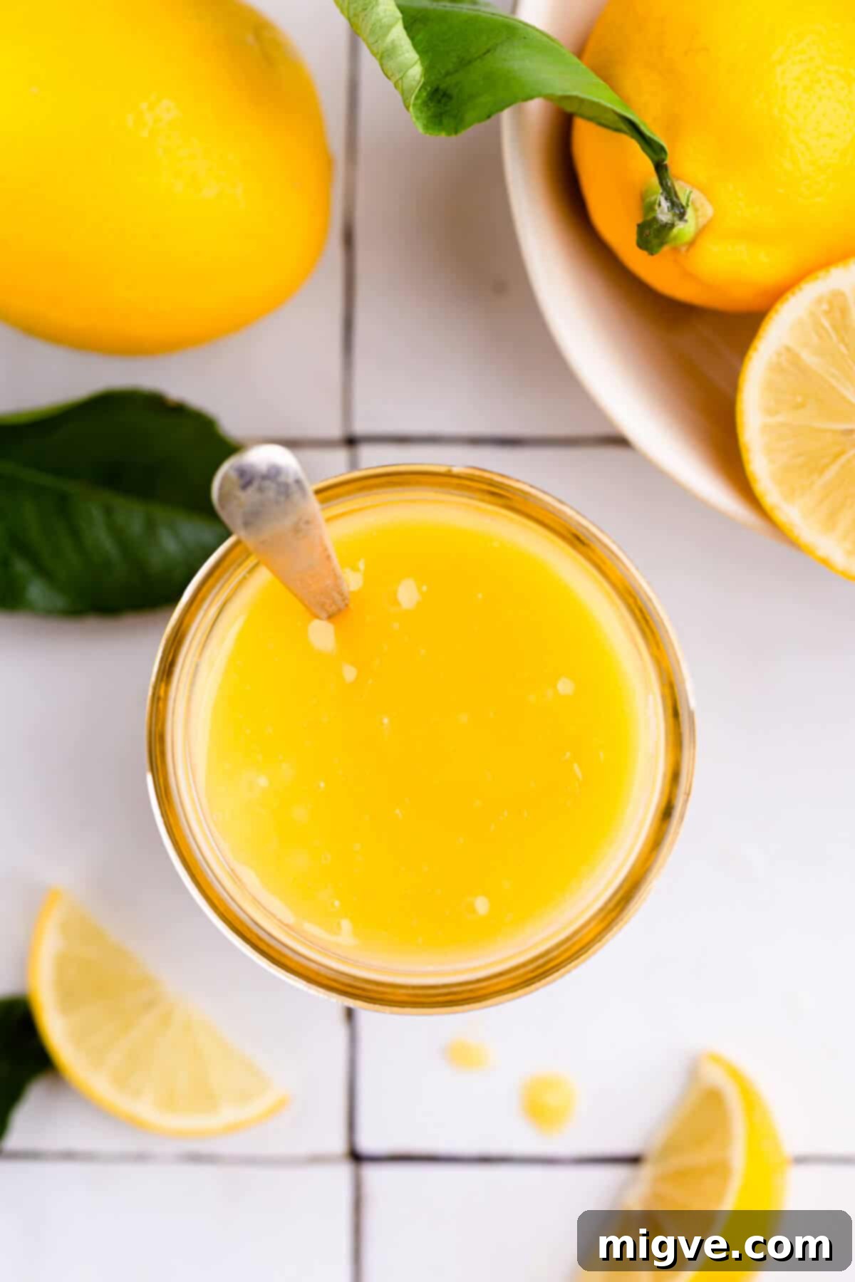 Handcrafted Lemon Zest Delight 13 overhead photo of a jar with fresh fruit curd and slices of lemon around it