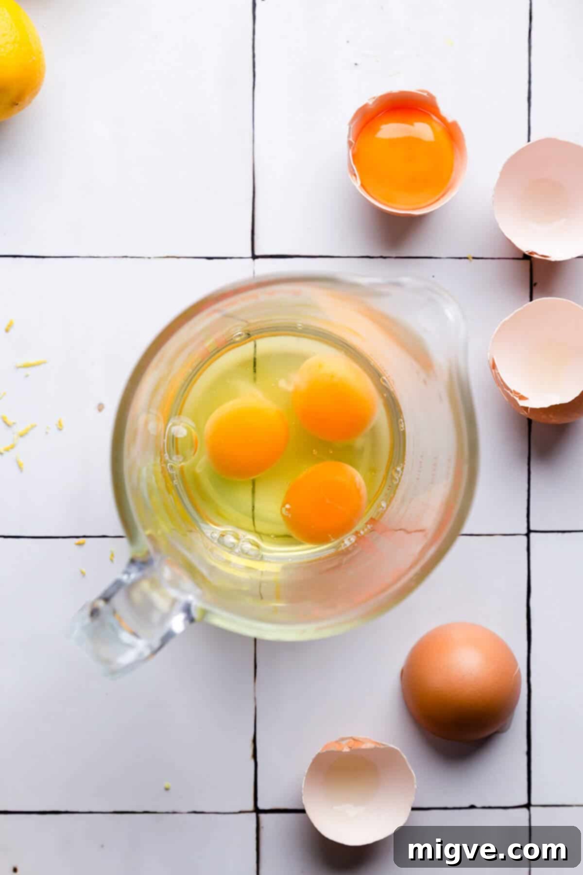 Handcrafted Lemon Zest Delight 7 overhead shot of a glass jar filled with 3 eggs and an egg yolk on side