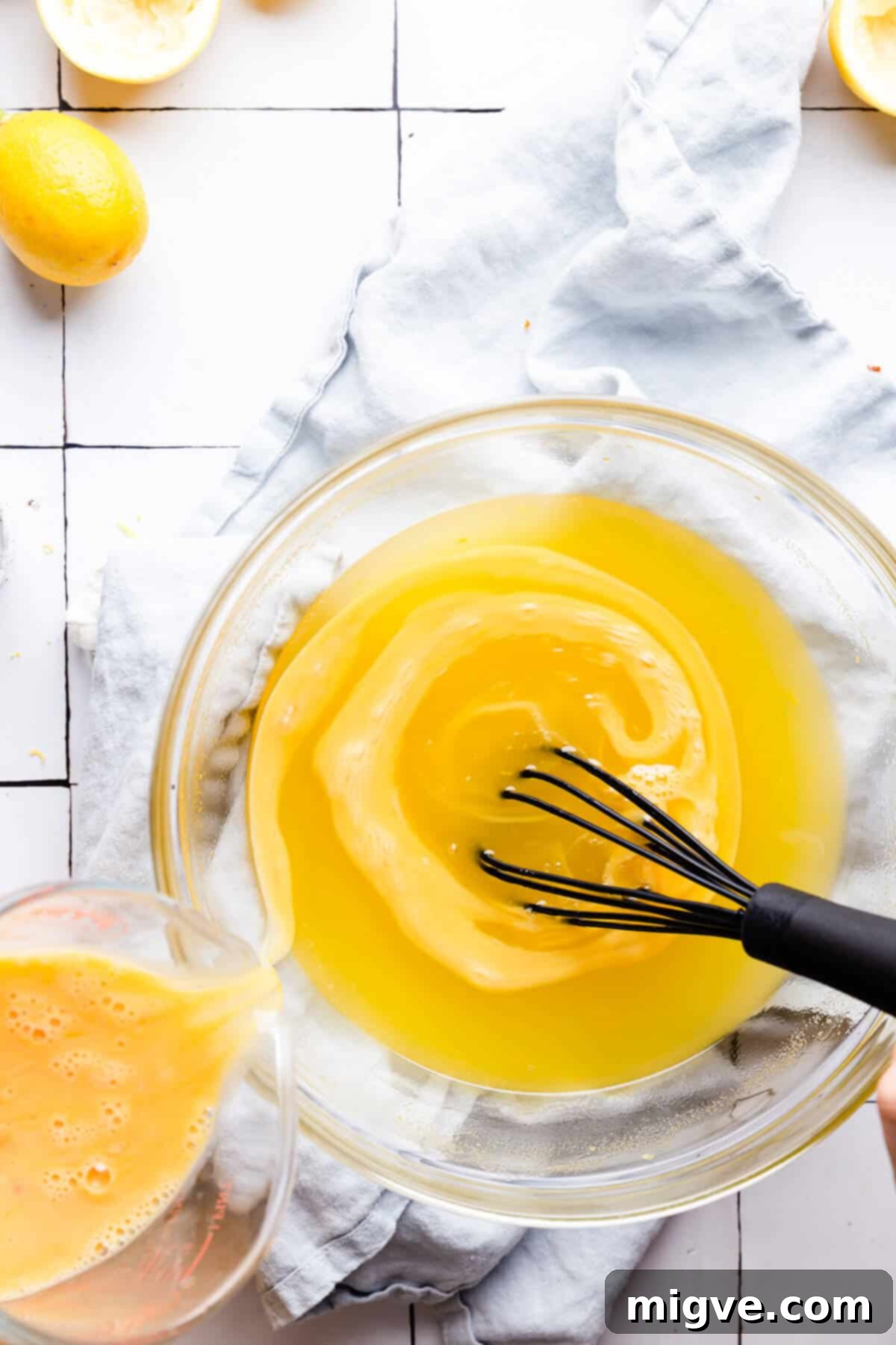 Handcrafted Lemon Zest Delight 8 top view of eggs being added to a bowl with curd mixture