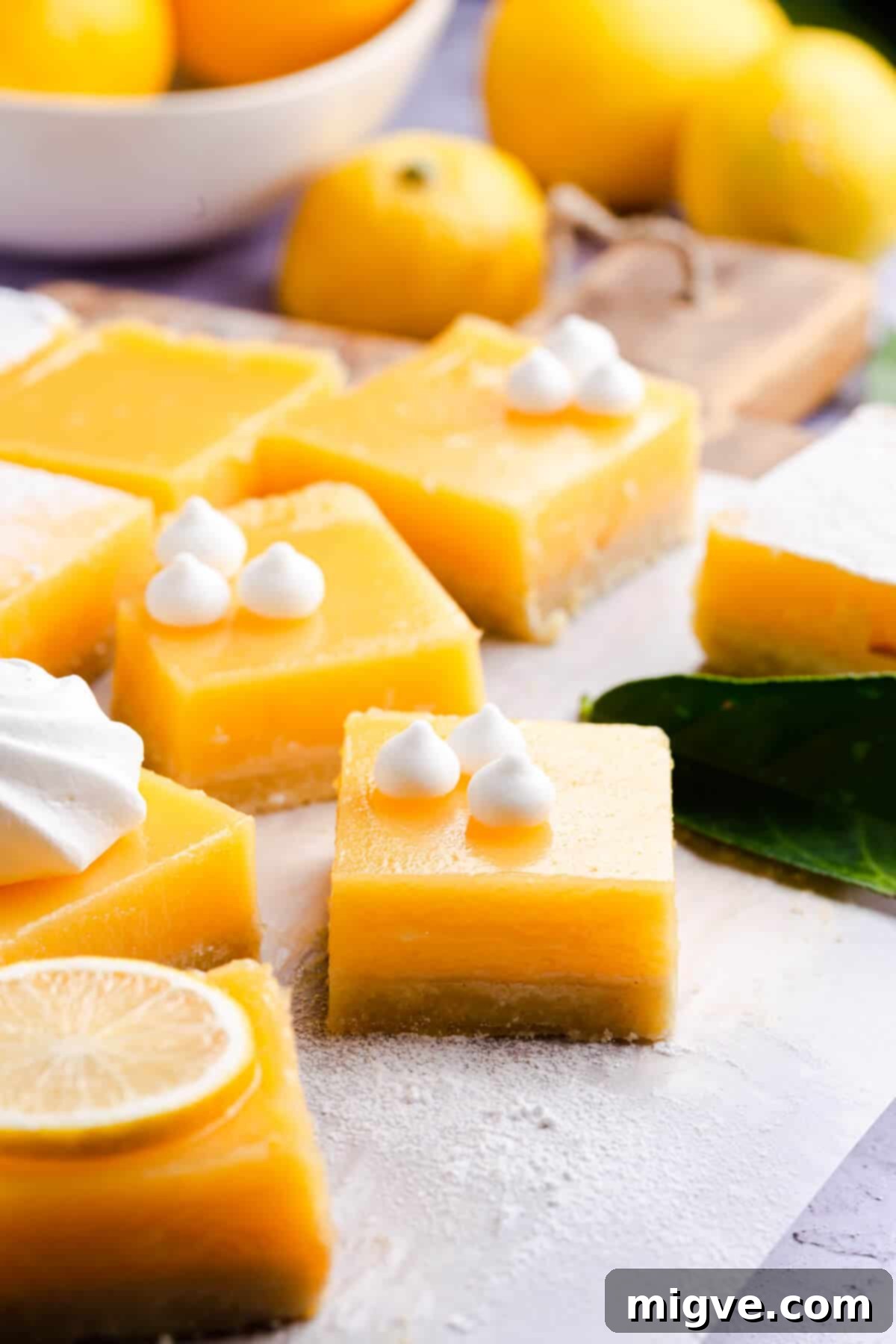 Side close up of lemon bars with shortcrust base, highlighting their delicious layers and golden color.