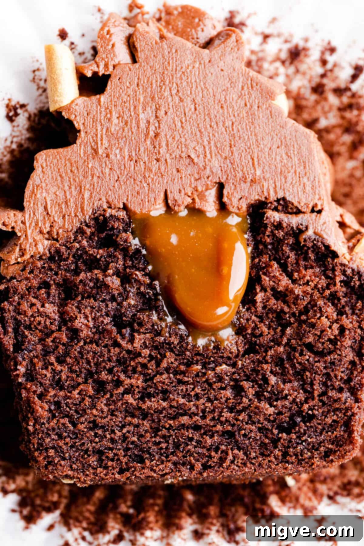 Super close up of a chocolate cupcake sliced in half, showcasing a luscious filling in the middle, ready to be devoured.