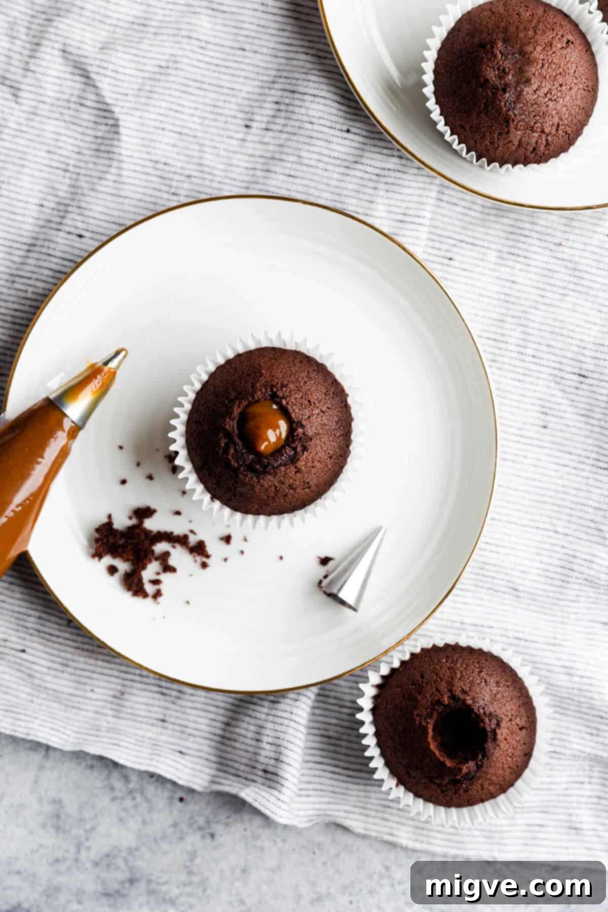 Overhead shot of a chocolate cupcake with a delicious dulce de leche filling visible, topped with a small swirl of buttercream.