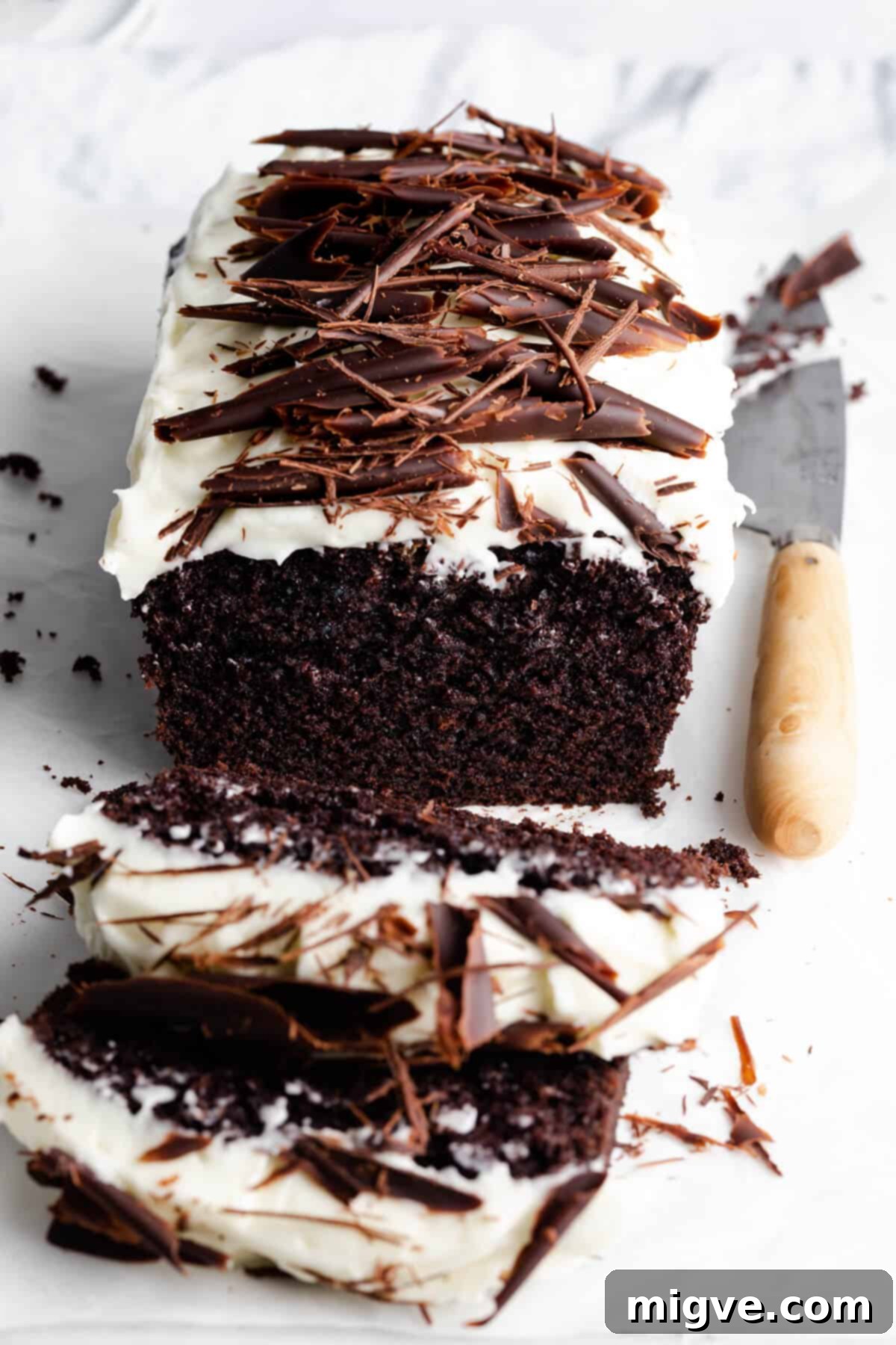 side angle photo of Guinness chocolate loaf cake with couple of slice cut of