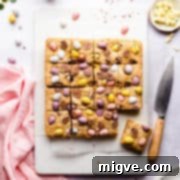 Speckled Spring Blondies 12 top view photo of blondie cake cut into square slices topped with mini eggs