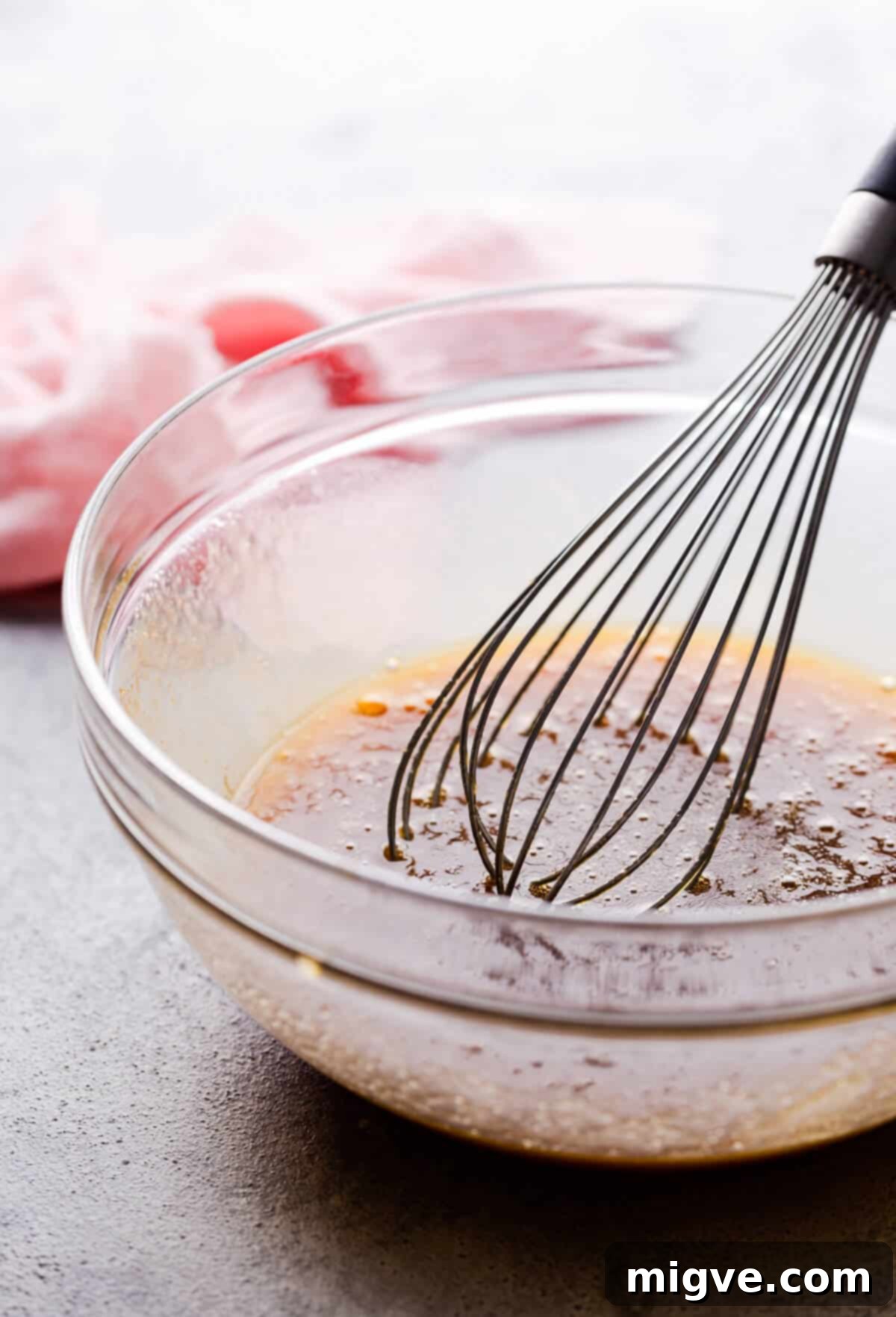 Speckled Spring Blondies 5 Side angle close-up photo of a bowl filled with a rich, golden cake batter, showcasing its smooth texture.