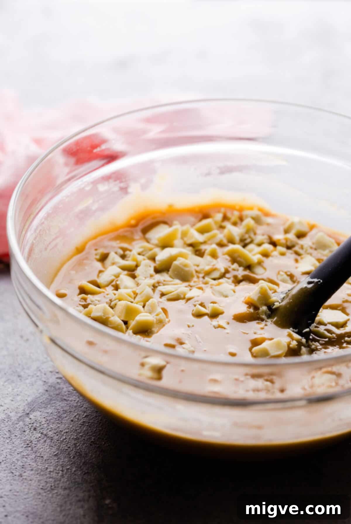 Speckled Spring Blondies 6 Side angle close-up photo of a bowl with creamy cake batter mixed with white chocolate chunks, ready for baking.