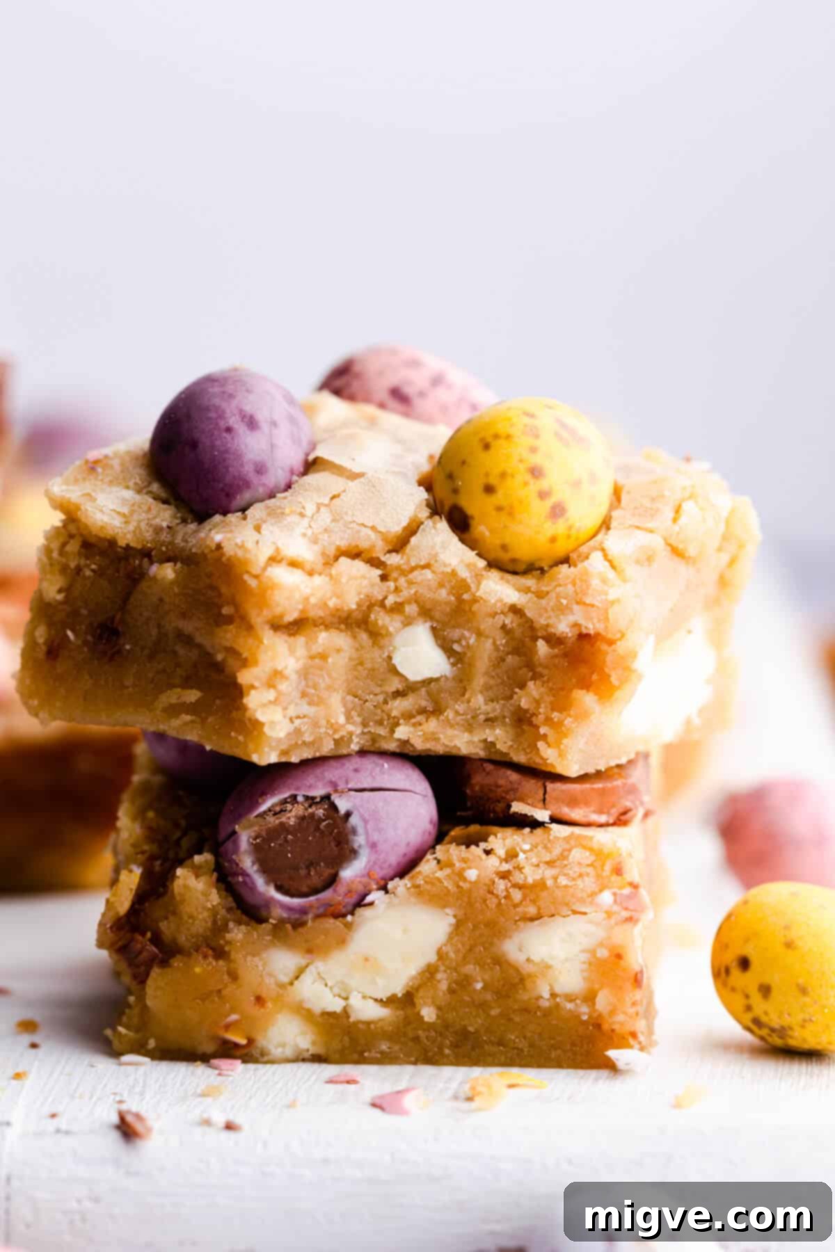 Speckled Spring Blondies 10 Side super close-up of two perfectly cut square slices of mini egg blondies, showing their rich texture.