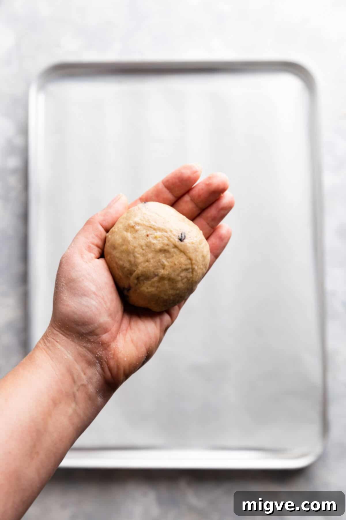 Luscious Blueberry Hot Cross Buns 8 a close up at a hand holding a ball of dough