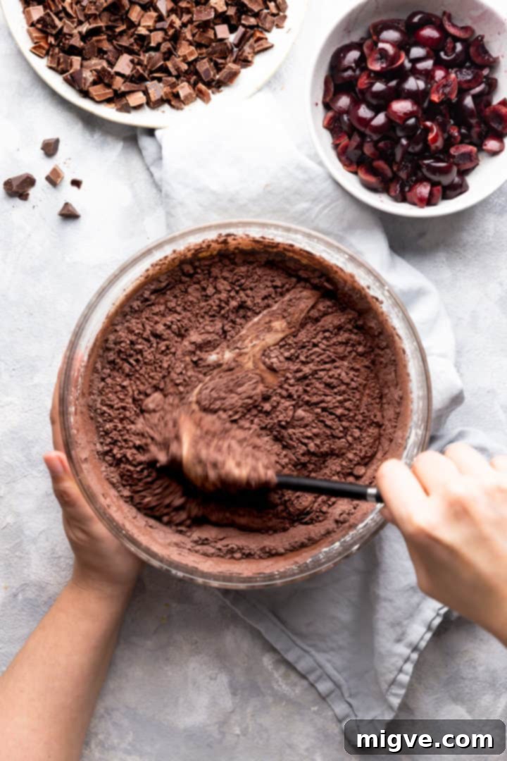 overhead shot of person folding dry ingredients into wet
