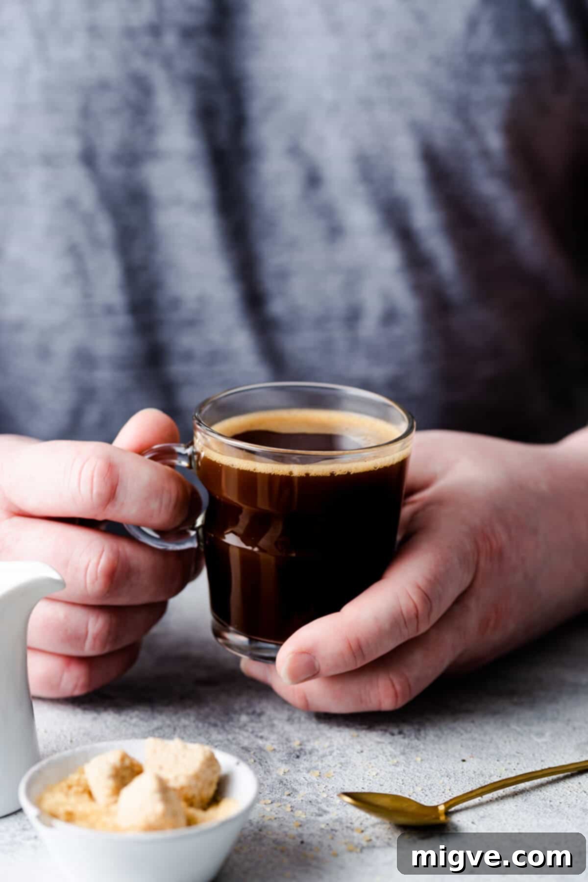 A close-up view of a person gently holding a warm, inviting cup of coffee, symbolizing comfort and the perfect morning brew.