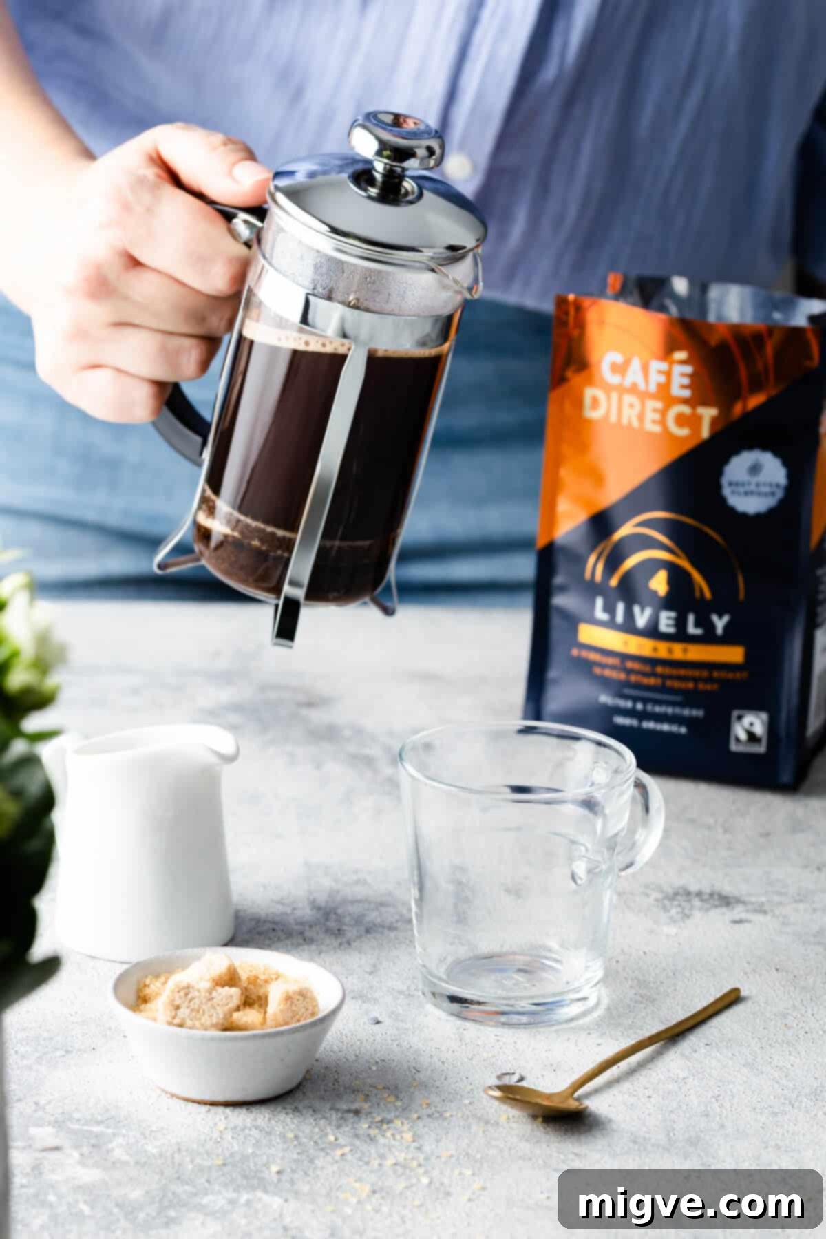 A person expertly preparing coffee using a classic cafetiere, highlighting the traditional brewing method for optimal flavor extraction.