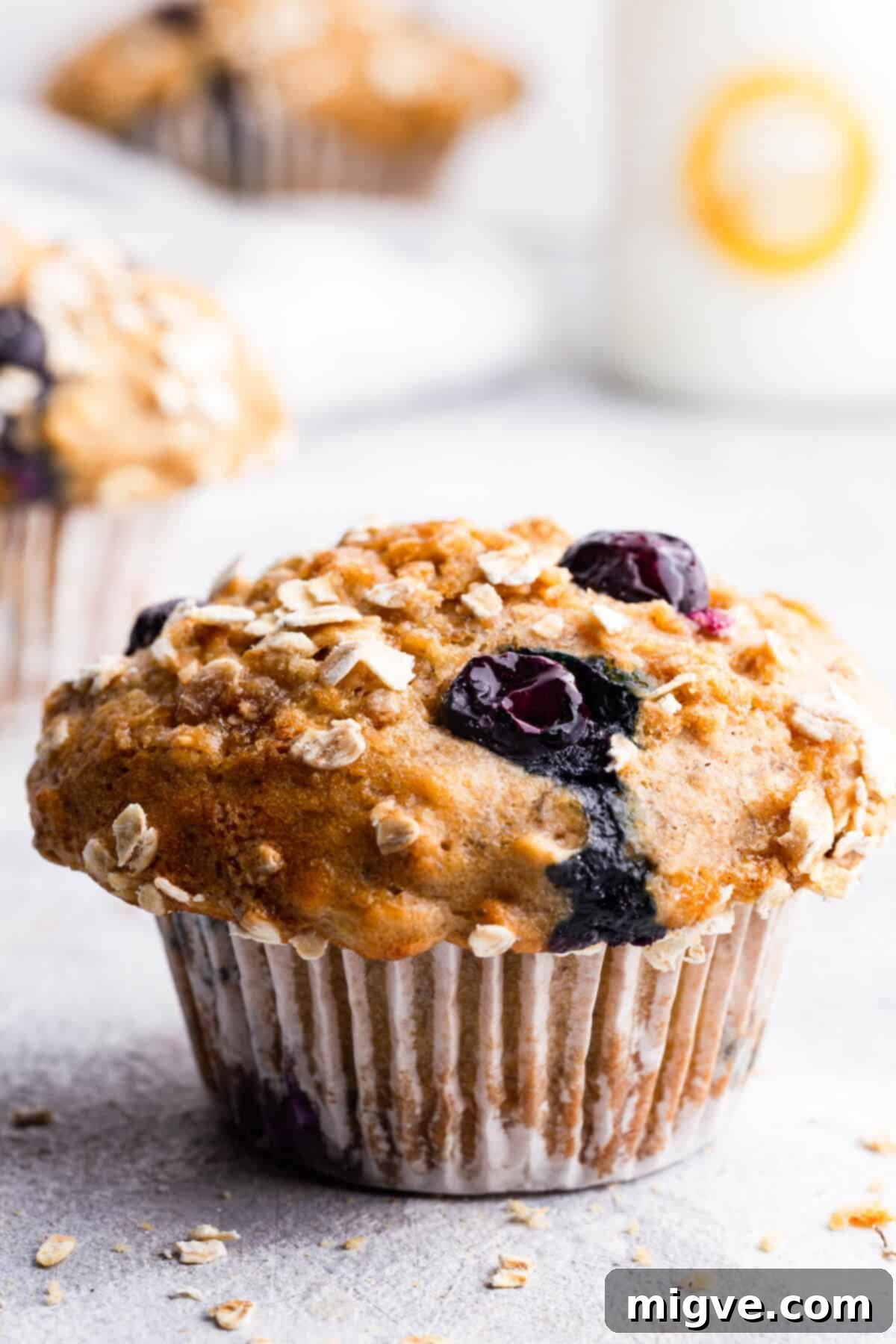 Super close-up side view of a moist banana and blueberry muffin, highlighting its fluffy texture and generous distribution of blueberries.